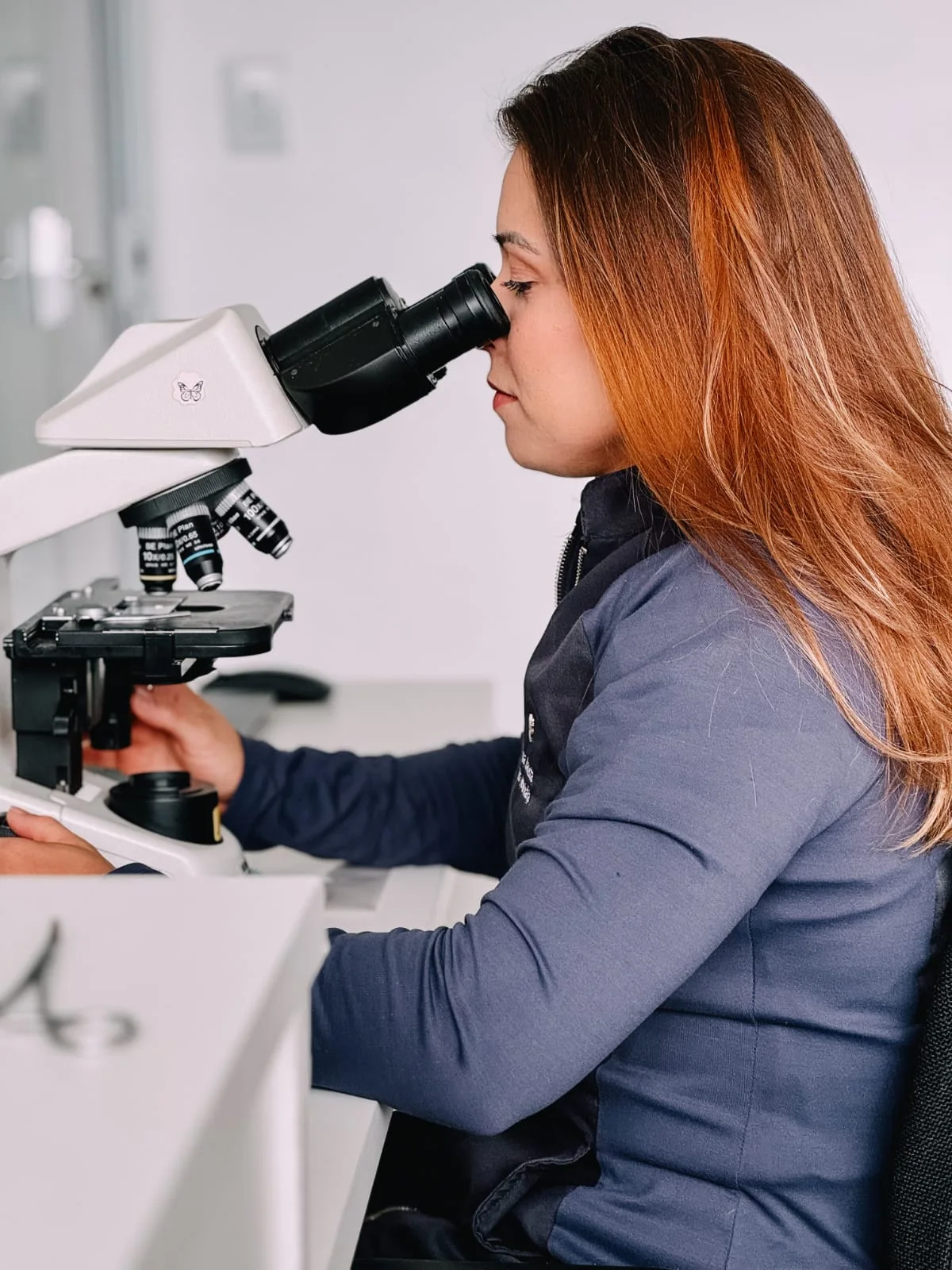 Dra. Érika Batista realizando análise em microscópio
